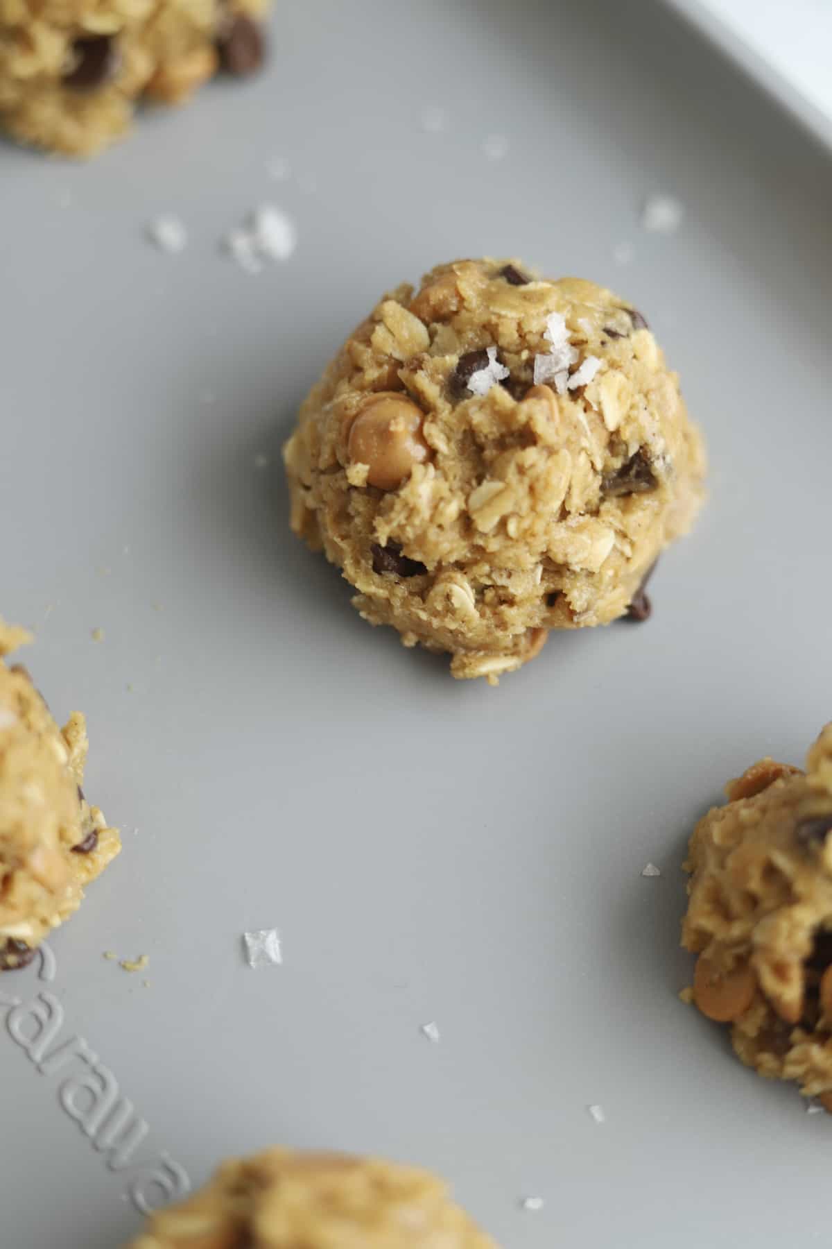 A ball of Crumbl Cookies Mom's Recipe copycat cookie dough on a baking sheet. 