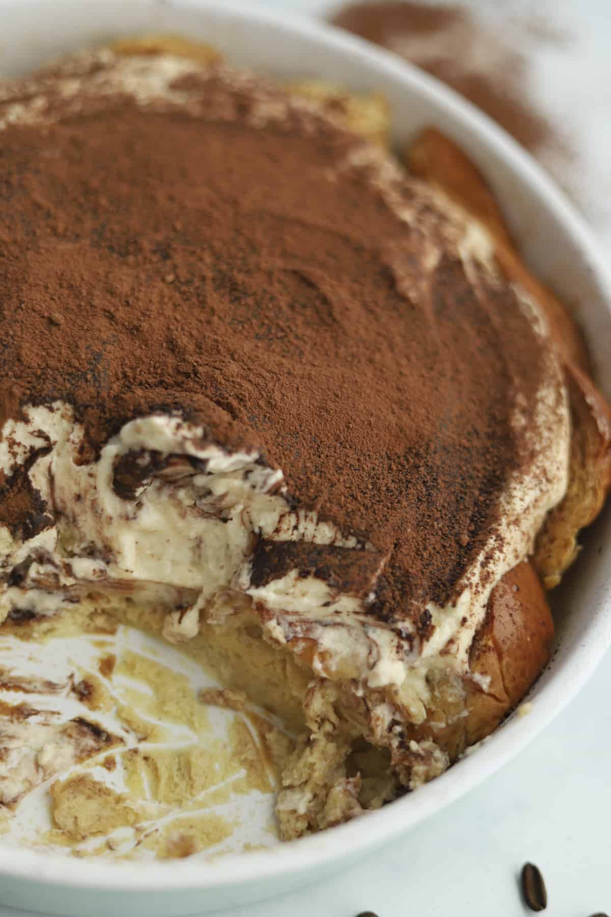 Tiramisú bread pudding with a large portion missing.