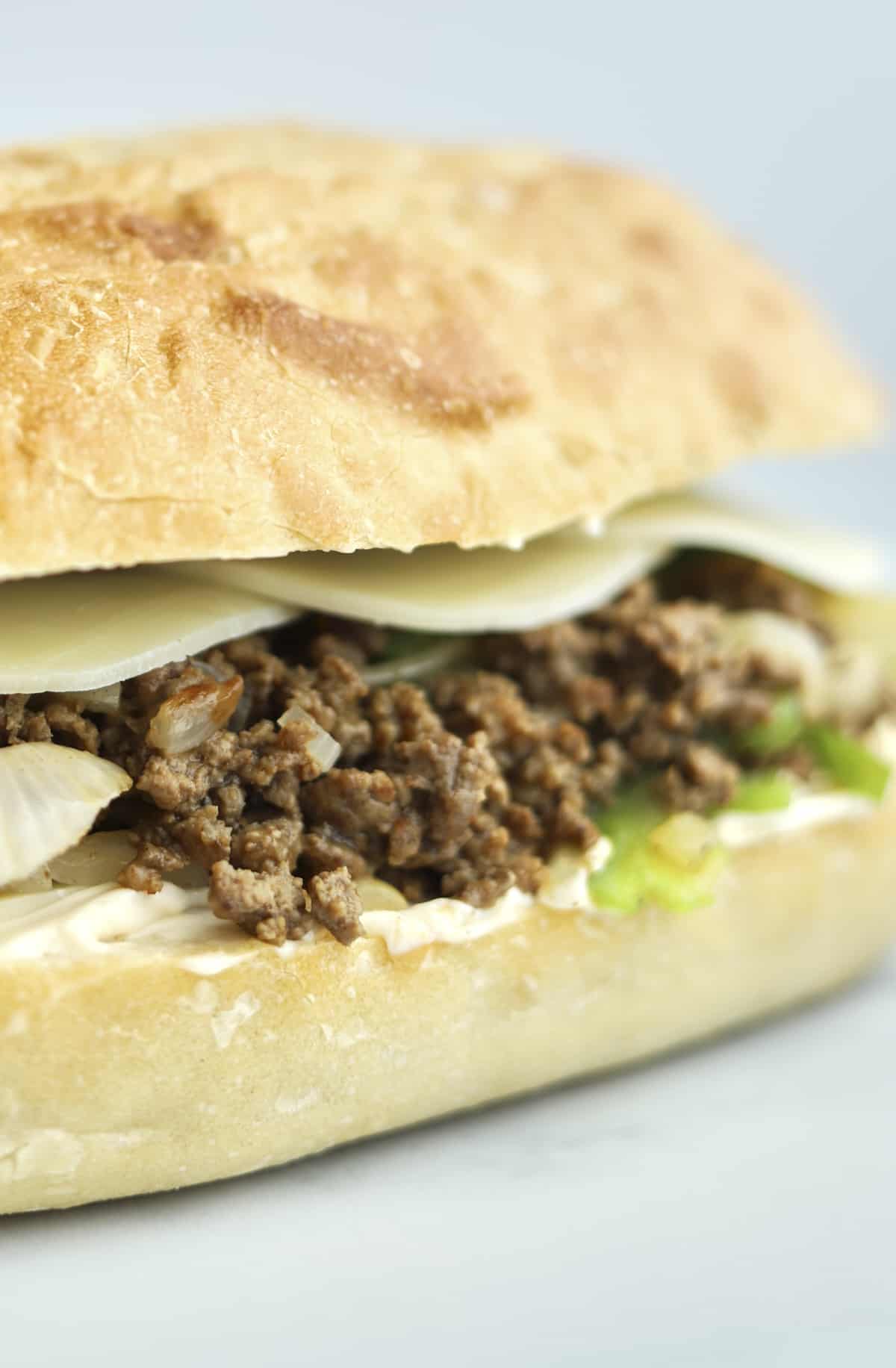sideview of a ground beef philly cheesesteak sandwich 
