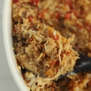 a spoonful of stuffed pepper rice bake being lifted from a casserole dish