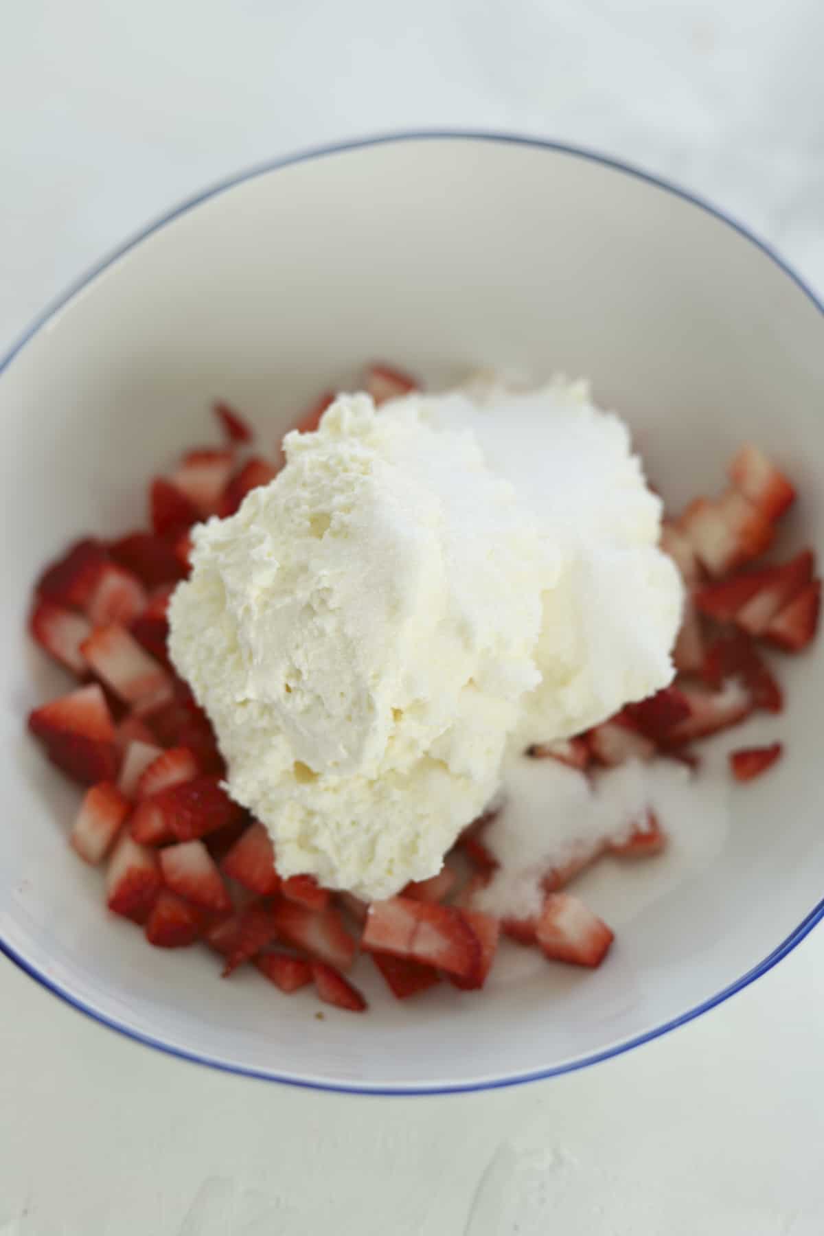 strawberries in a bowl with cream cheese on top 