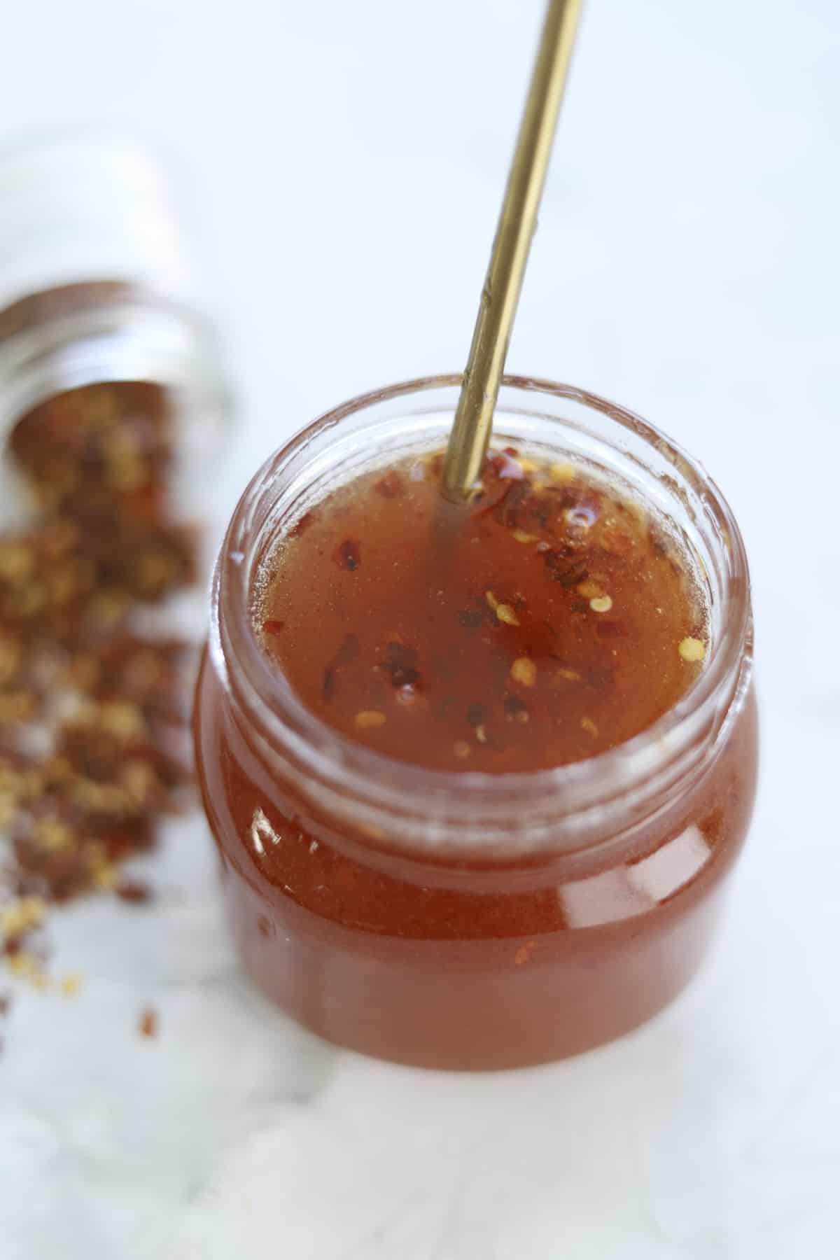 mason jar full of hot honey with a spoon sticking out