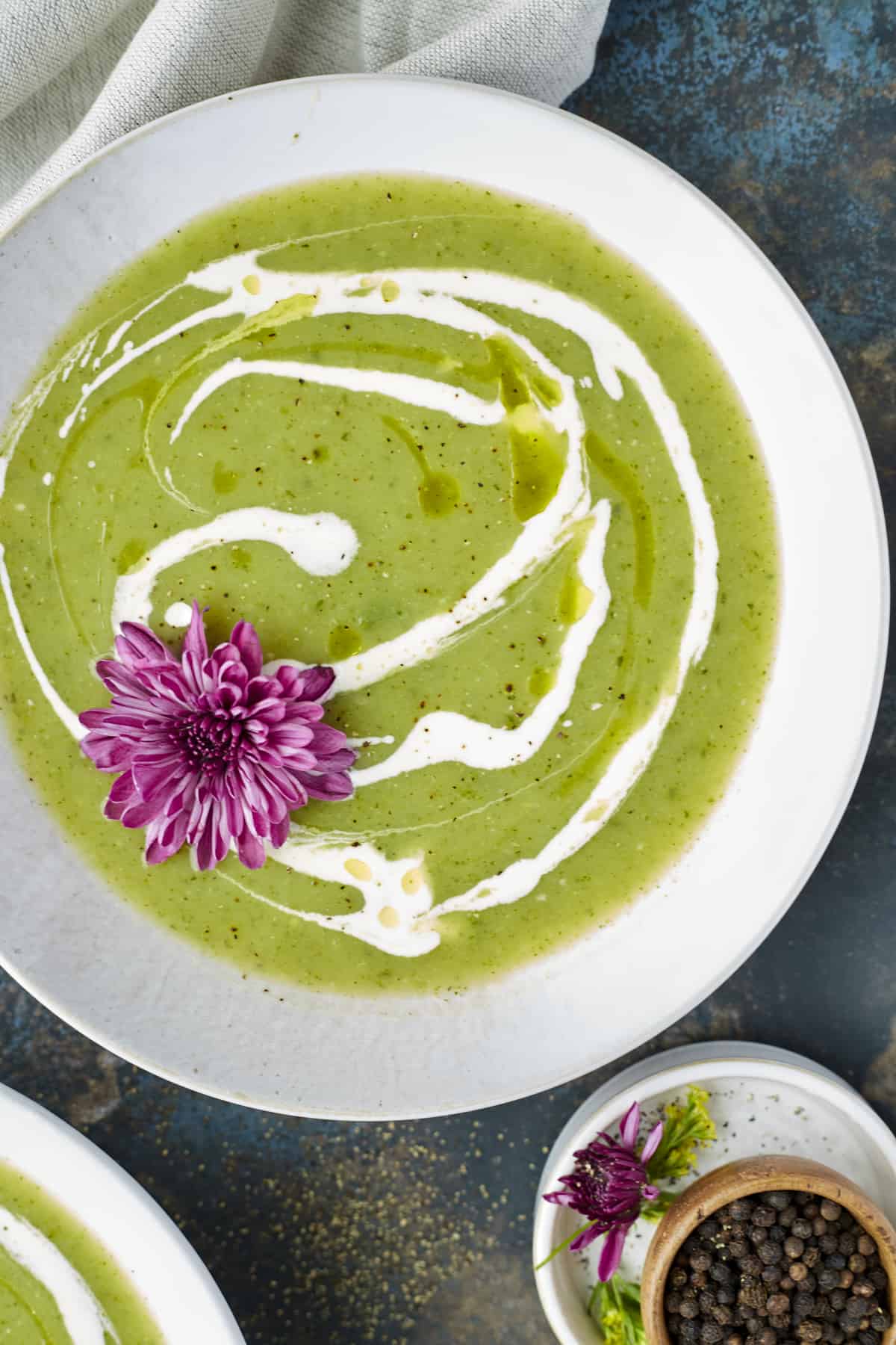 a bowl of zucchini soup topped with coconut milk