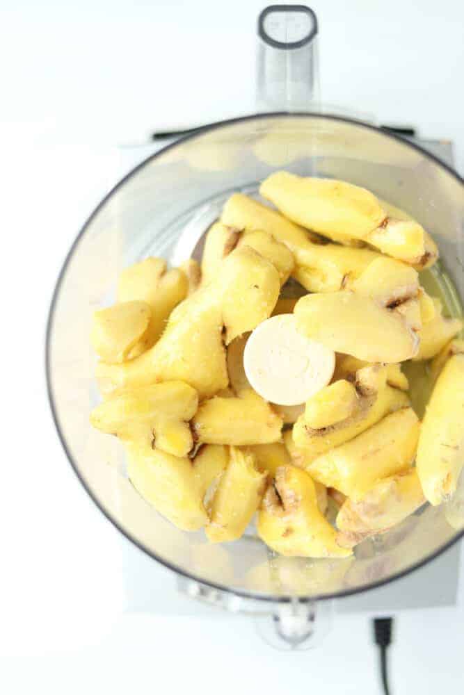 overhead image of peeled ginger in a food processor.