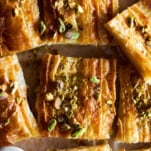 Squares of baked crinkle phyllo dough topped with pistachios.