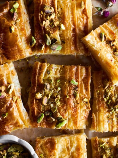 Squares of baked crinkle phyllo dough topped with pistachios.