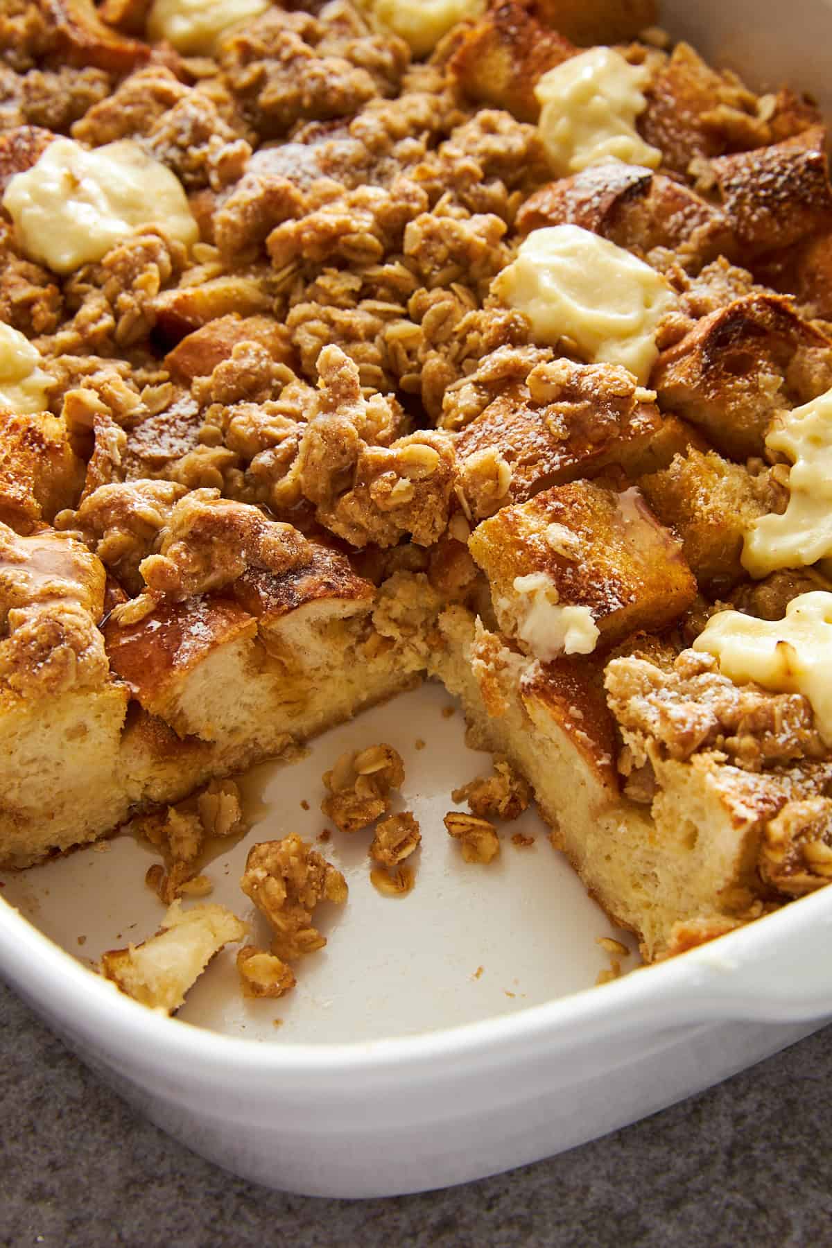 Cream cheese french toast casserole in a baking dish with a slice missing.