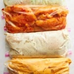 Four different flavored bags of marinating chicken.