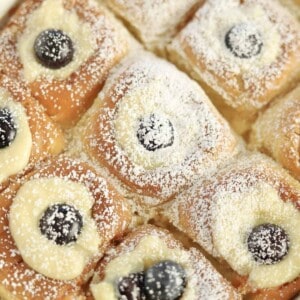 lemon blueberry french toast stuffed with a ricotta filling and topped with powdered sugar in a white baking dish