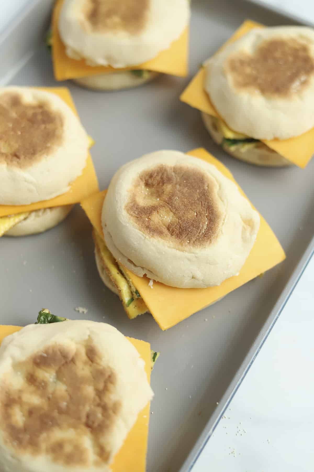 protein packed egg muffin sandwiches with raw American cheese squares on a baking dish