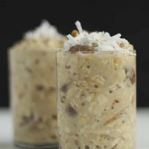 two jars of dates & apricots overnight oats topped with shredded coconut flakes