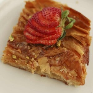 a piece of crinkle phyllo dough topped with sliced strawberries on a plate