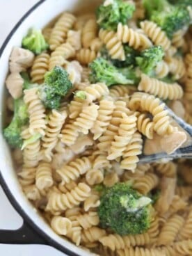 a spoon scooping up a bite from a pot of chicken broccoli rotini