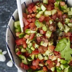 a bowl of Egyptian tomato & cucumber salad with a spoon sticking out