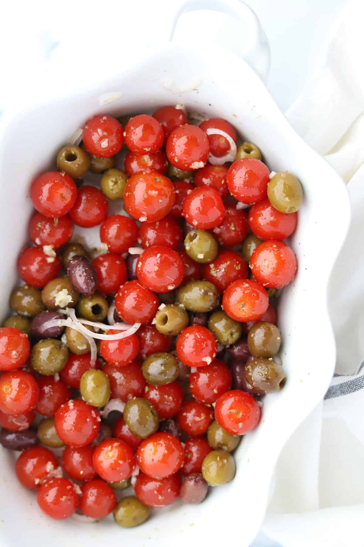 tomatoes and olives in a baking dish.