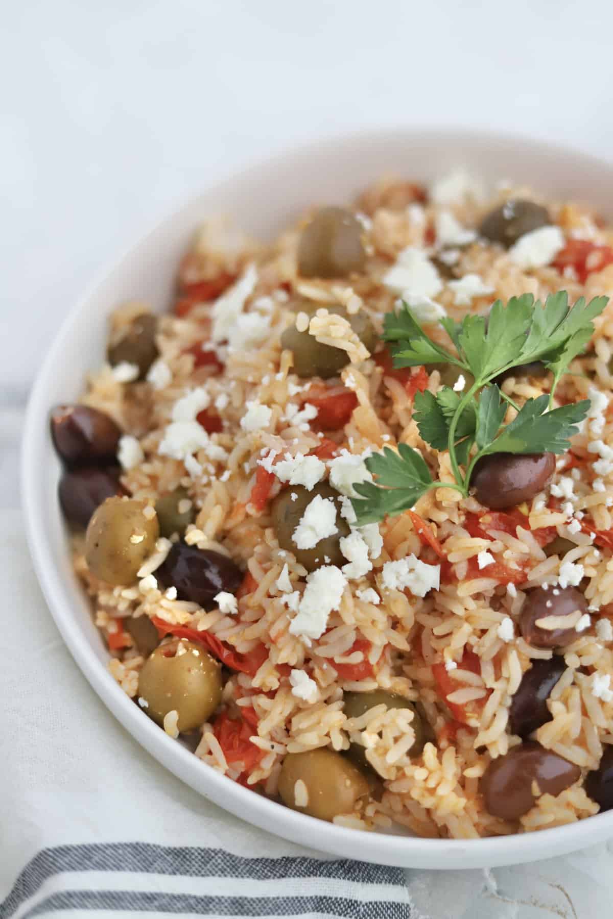 greek rice with tomatoes and olives in a bowl.