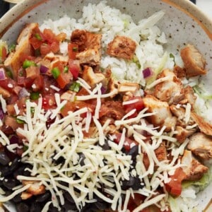 homemade chipotle bowl with chicken topped with cheese and black beans
