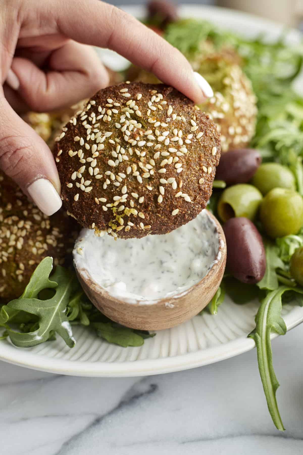 close up image of an air fryer falafel topped with sesame seeds