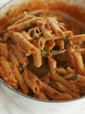 a spoon lifting up a serving of one pot sun-dried tomato pasta