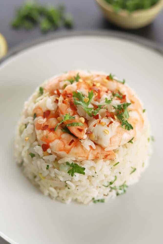 a serving of lemon garlic shrimp and rice on a white plate