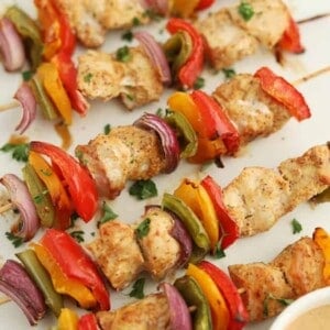 sheet pan of chicken skewers with colored peppers and onions