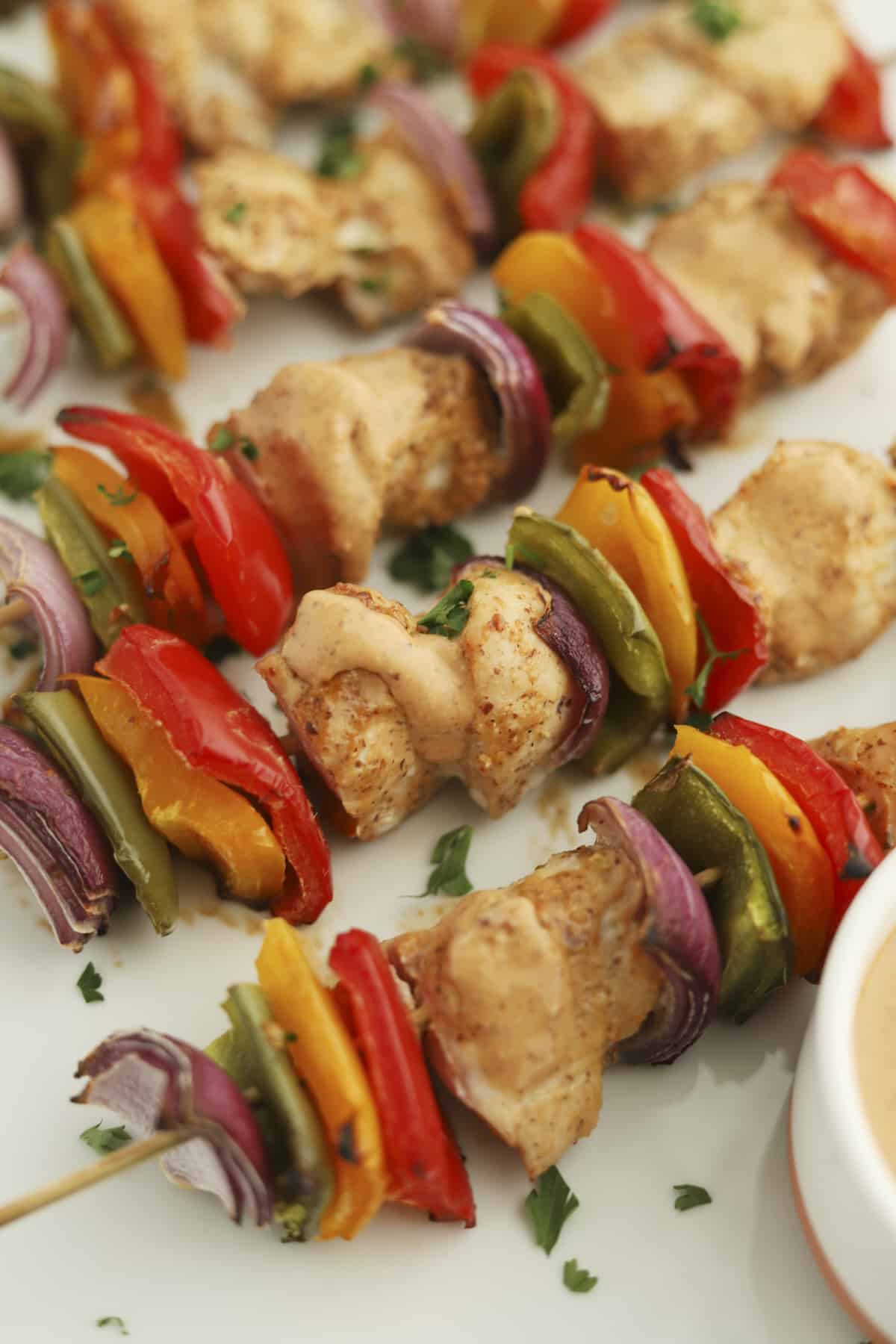 oven-baked chipotle chicken skewers with red, yellow, and green peppers and red onion