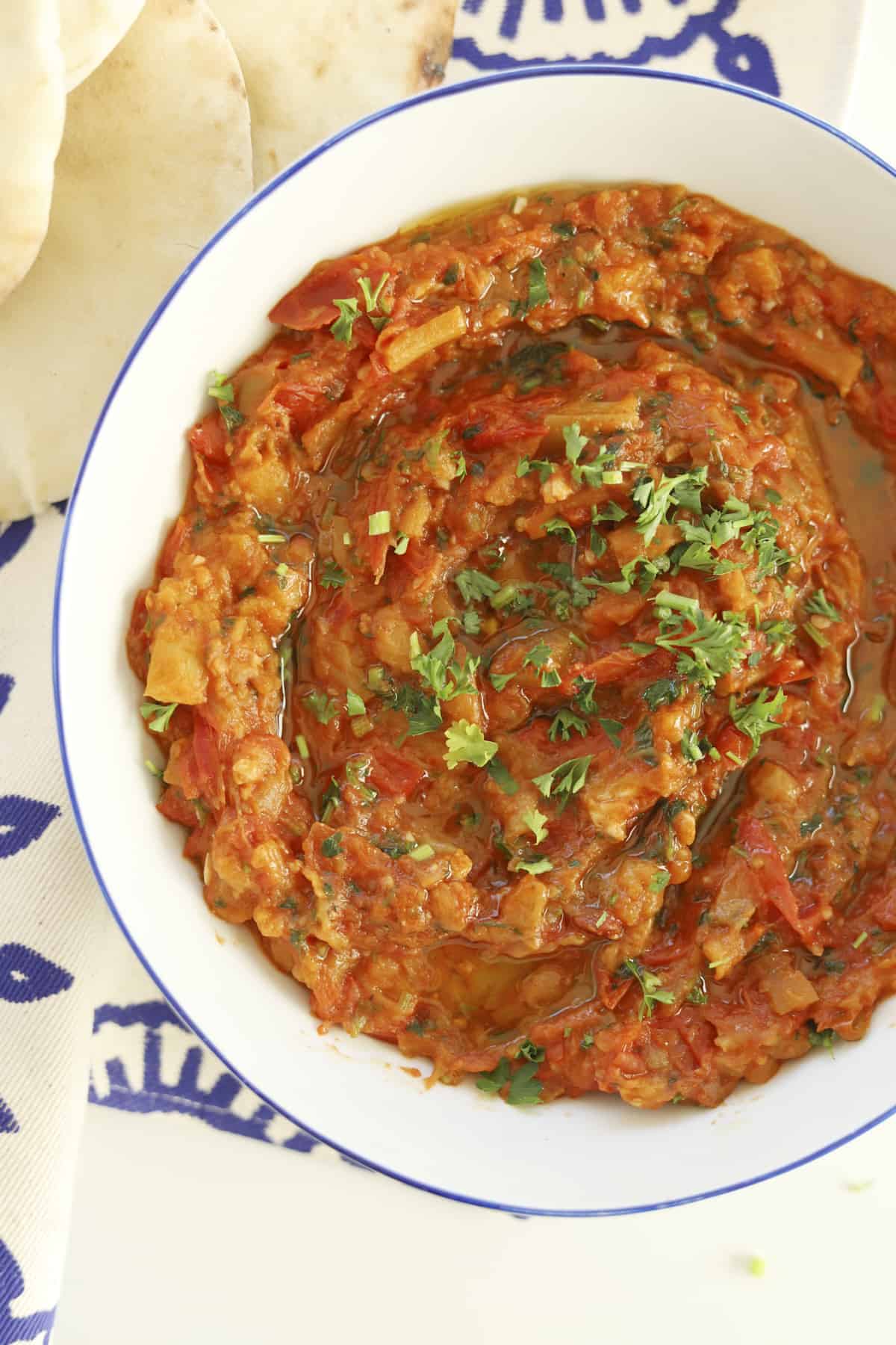 closeup overhead zaalouk with olive oil and fresh parsley