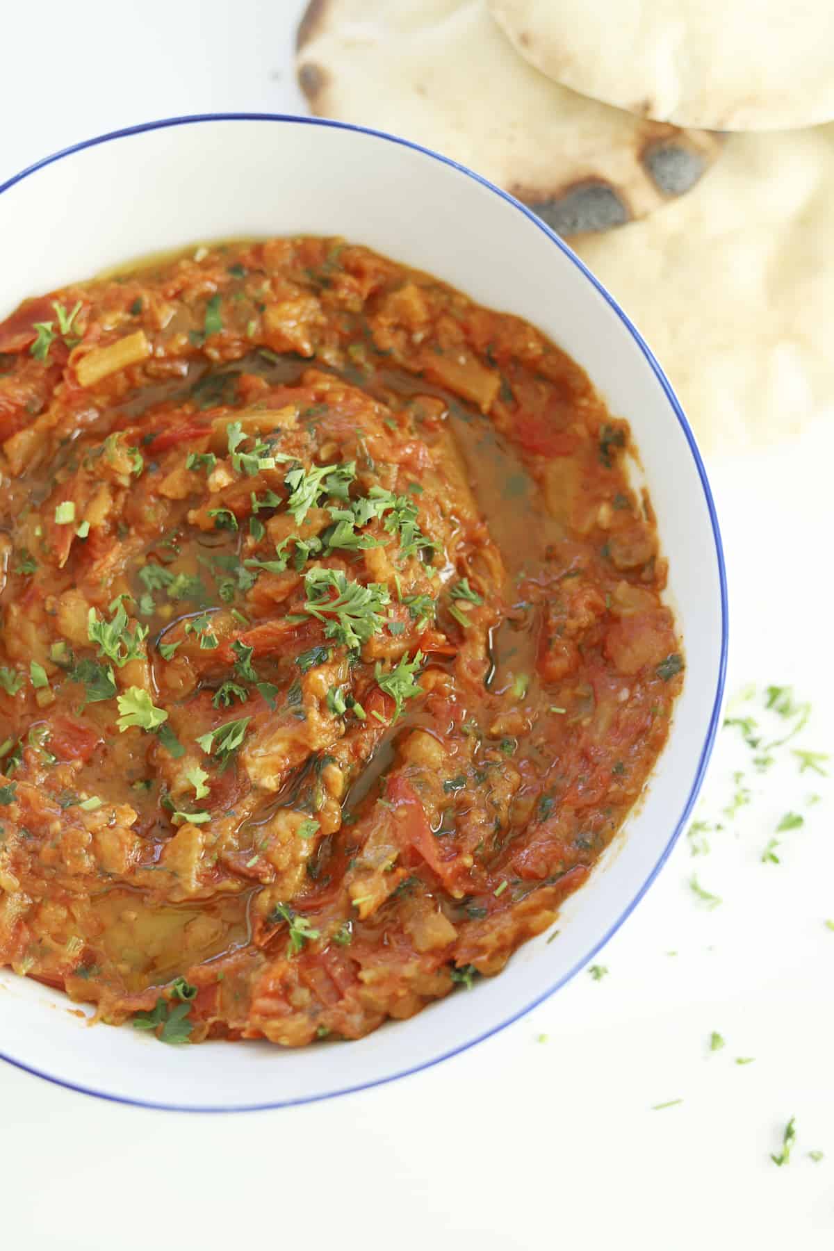 Moroccan zaalouk in a bowl topped with fresh herbs