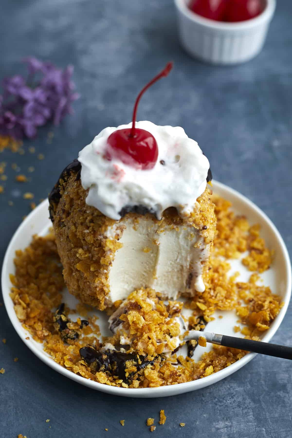 fried ice cream on a plate with a bite taken out.