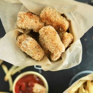 a basket of crispy baked chicken nuggets with ketchup on the side