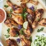 baked peri peri chicken drumsticks in a baking dish on top of parchment paper