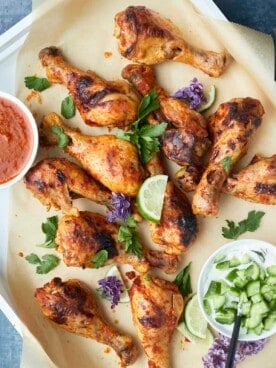 baked peri peri chicken drumsticks in a baking dish on top of parchment paper