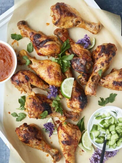 baked peri peri chicken drumsticks in a baking dish on top of parchment paper