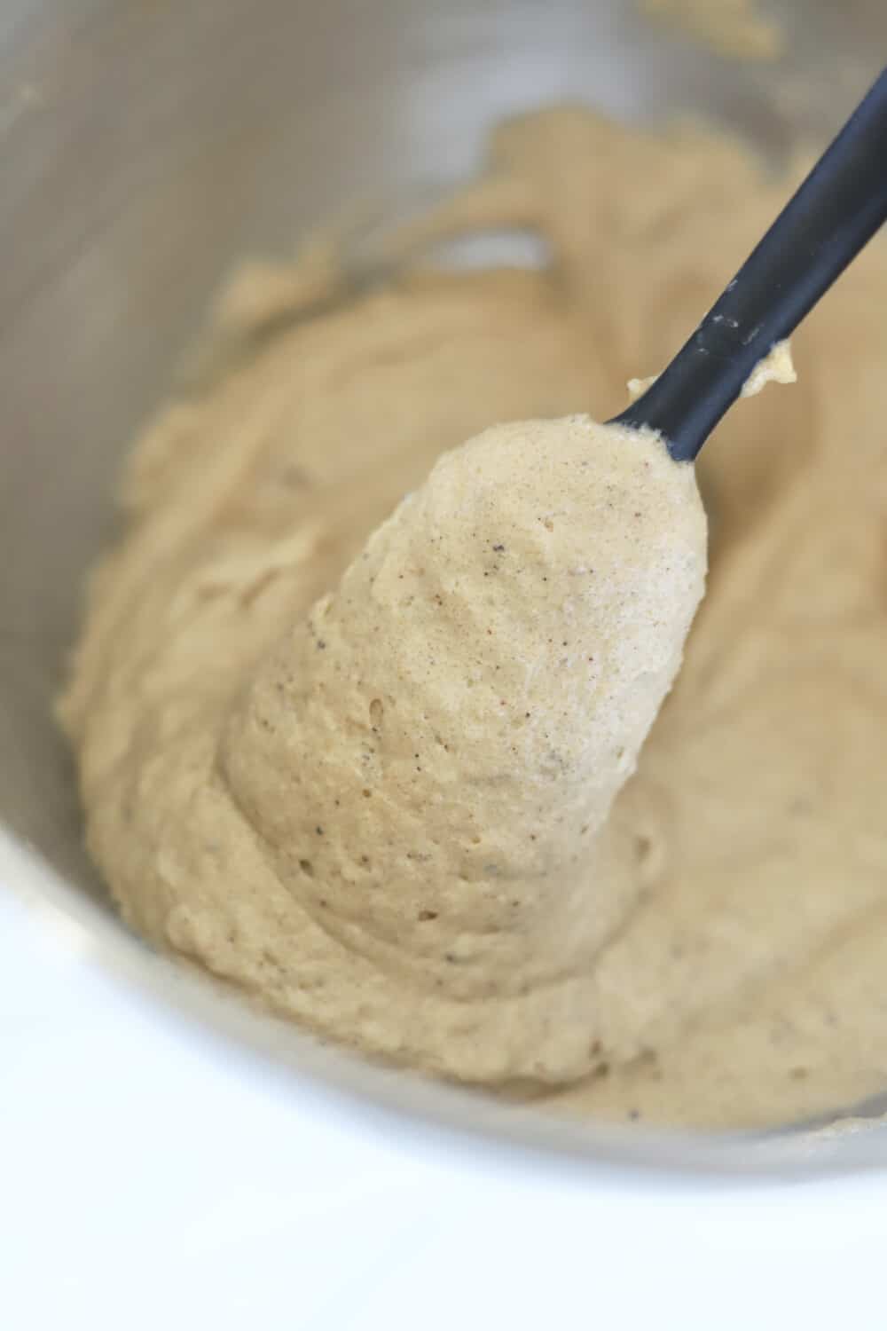 easy toffee cookie batter in a large mixing bowl on a plastic spoon