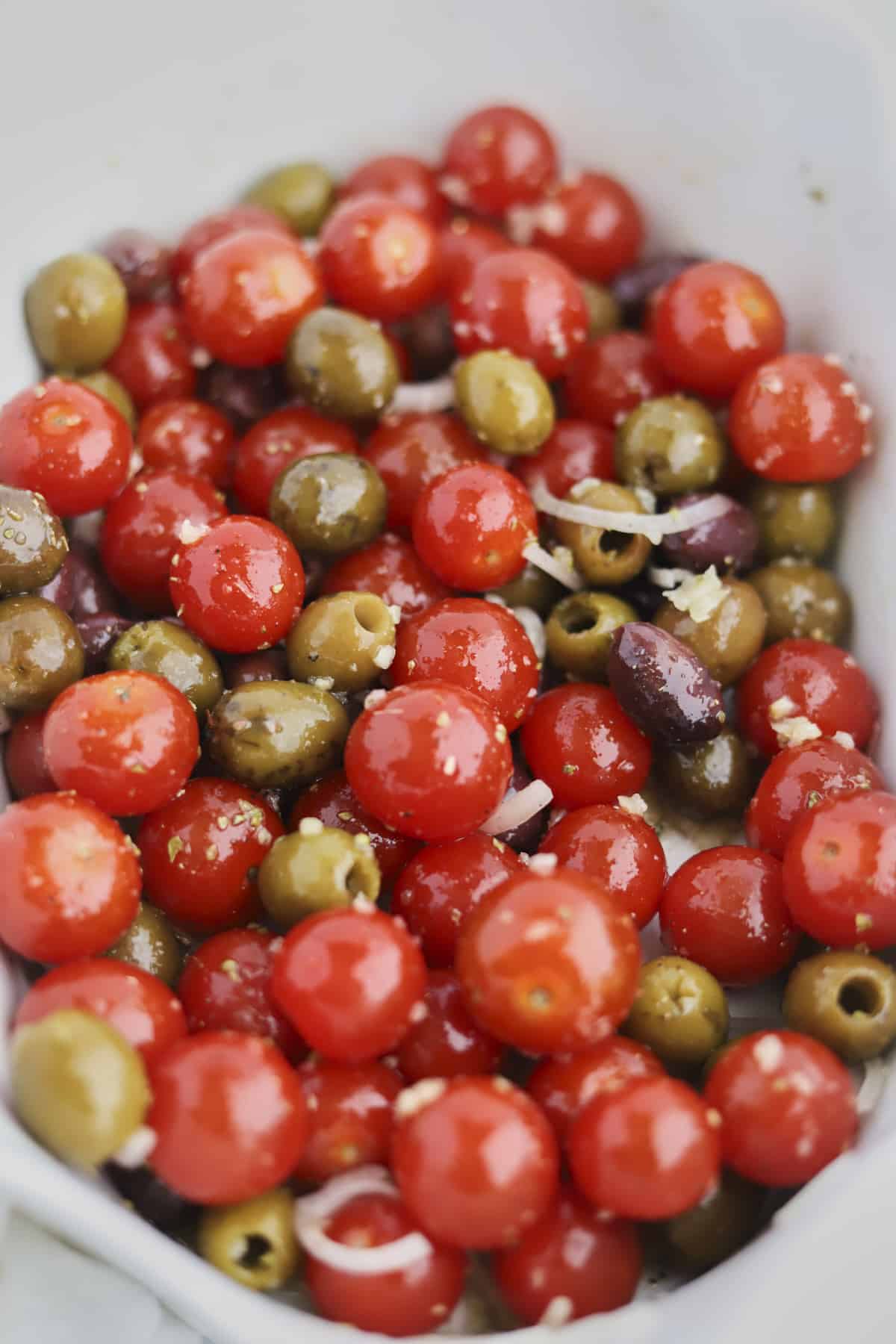 baking dish of tomatoes, olives, onions and olive oil