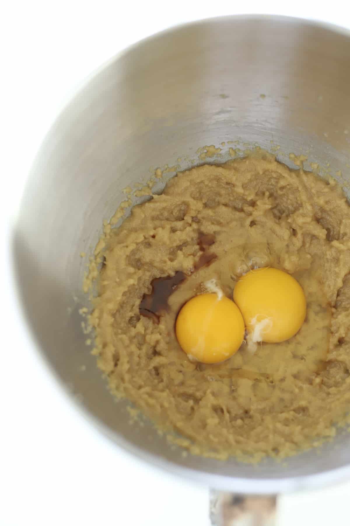 eggs and vanilla over creamed butter and sugar in a mixing bowl 