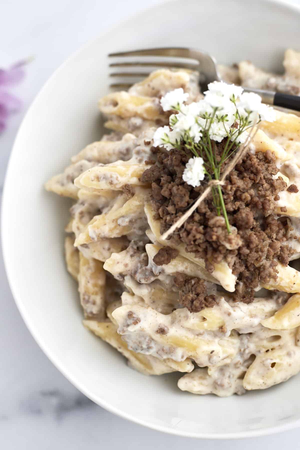 macarona bechamel on a plate topped with ground beef