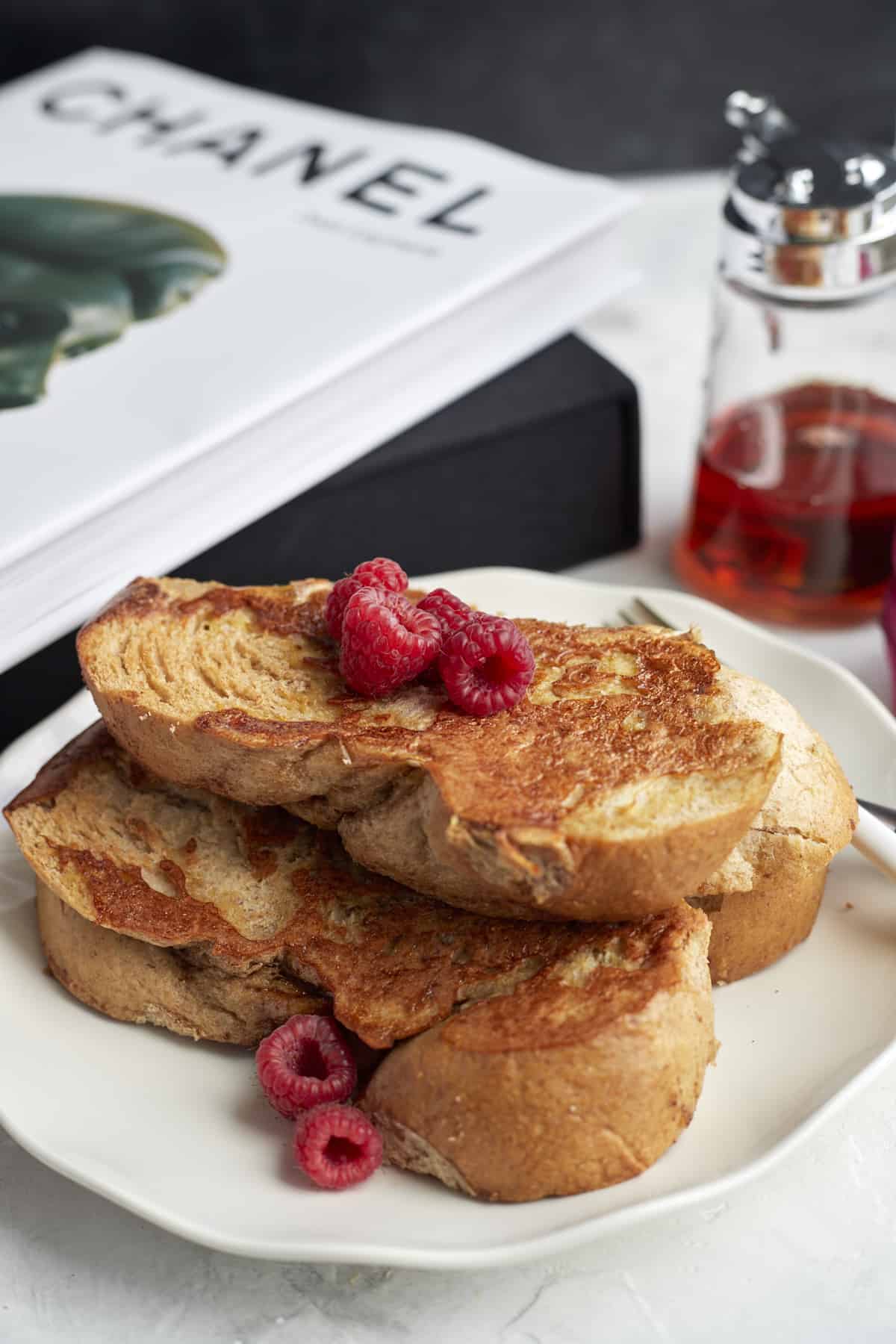 a plate of sheet pan french toast topped with raspberries