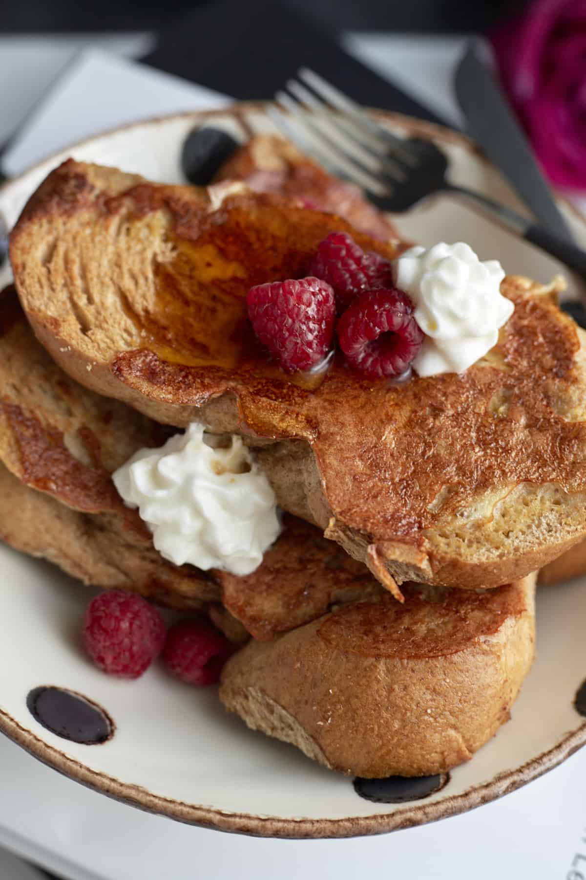 plated sheet pan french toast with raspberries and whipped cream 