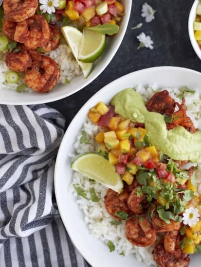 two bowls of blackened shrimp with cilantro lime dressing, rice, and mango salsa.