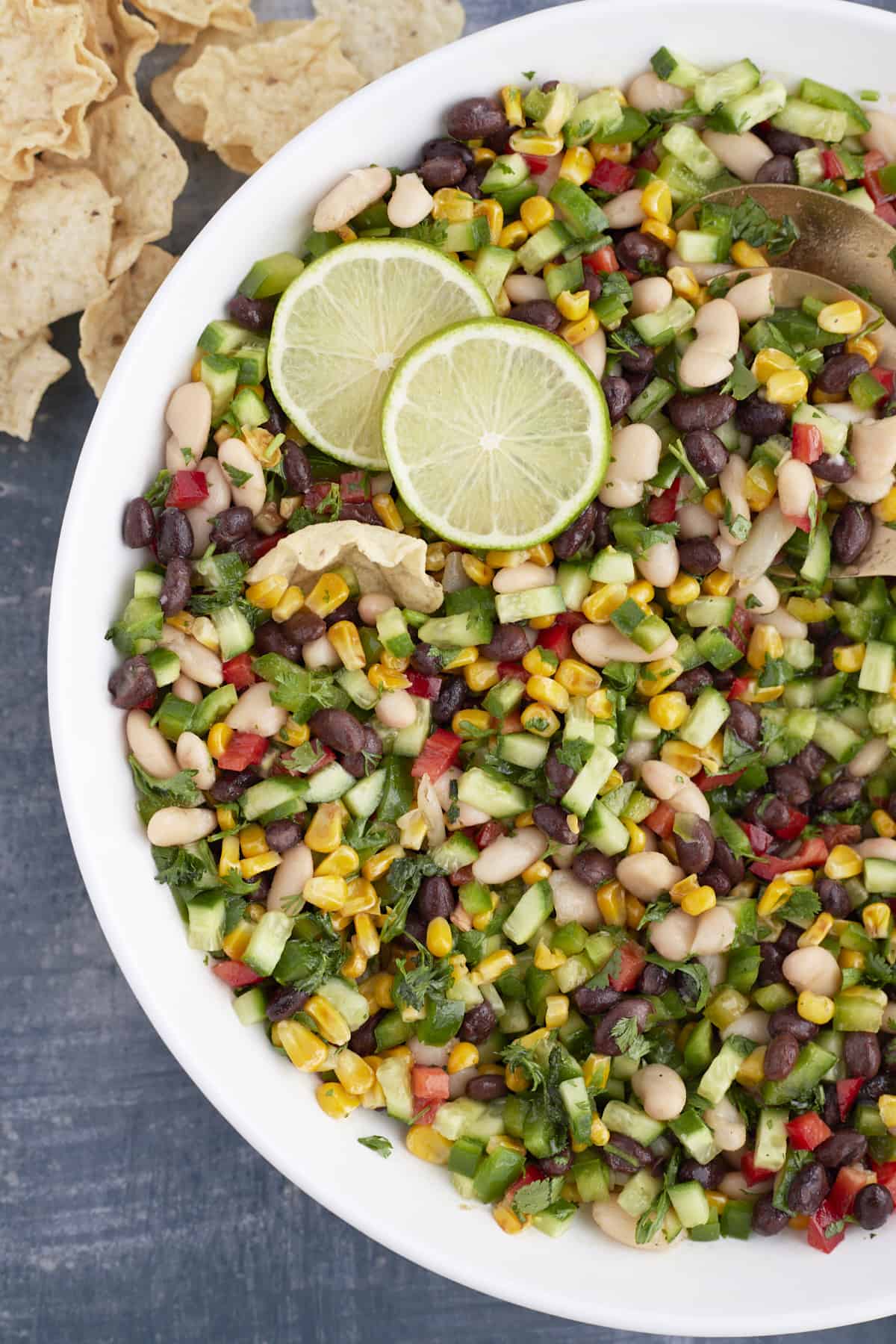 large white bowl with cowboy caviar, limes, and gold spring spoons