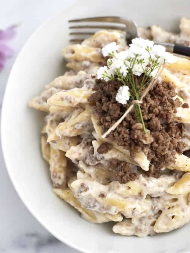 One Pot Macarona Bechamel in a white pot topped with white flowers for garnish