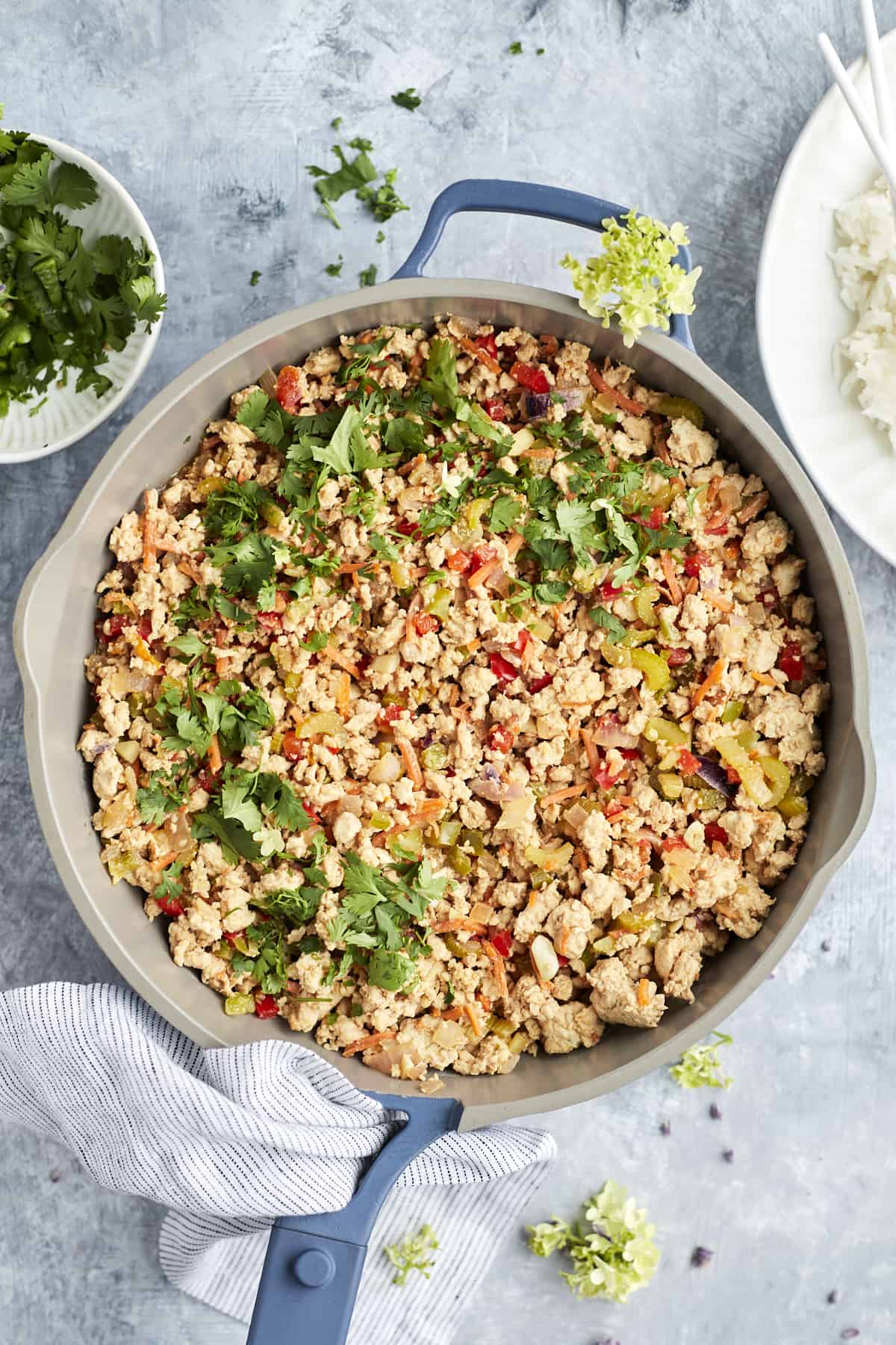 overhead image of Asian Chicken in a skillet topped with peanuts and cilantro.