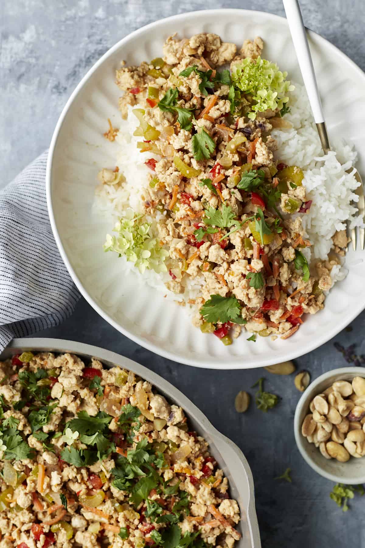 a plate with rice and Asian chicken bowl and a skillet full of Asian chicken.