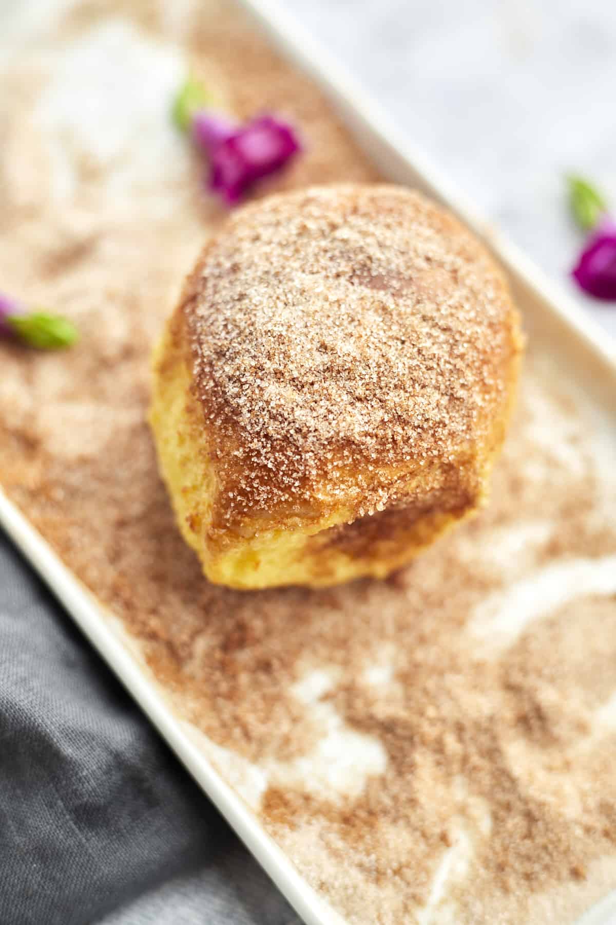 a close up image of a cinnamon bun air fryer french toast bun