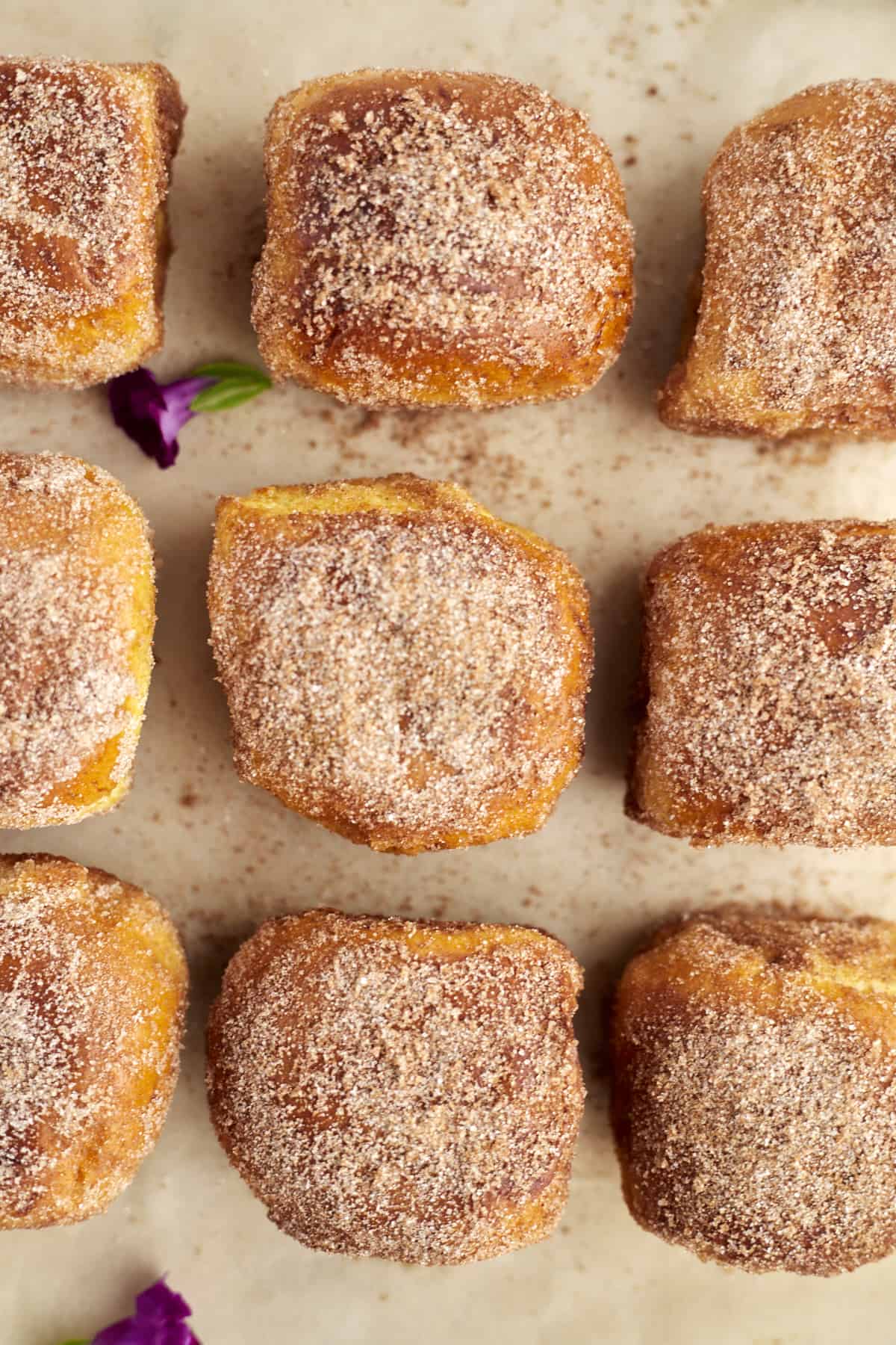 nine buns arranged on parchment paper and topped with an extra sprinkle of cinnamon sugar