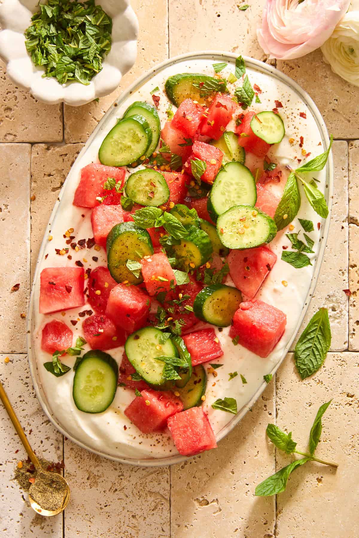 A platter of whipped feta topped with watermelon cucumber salad.
