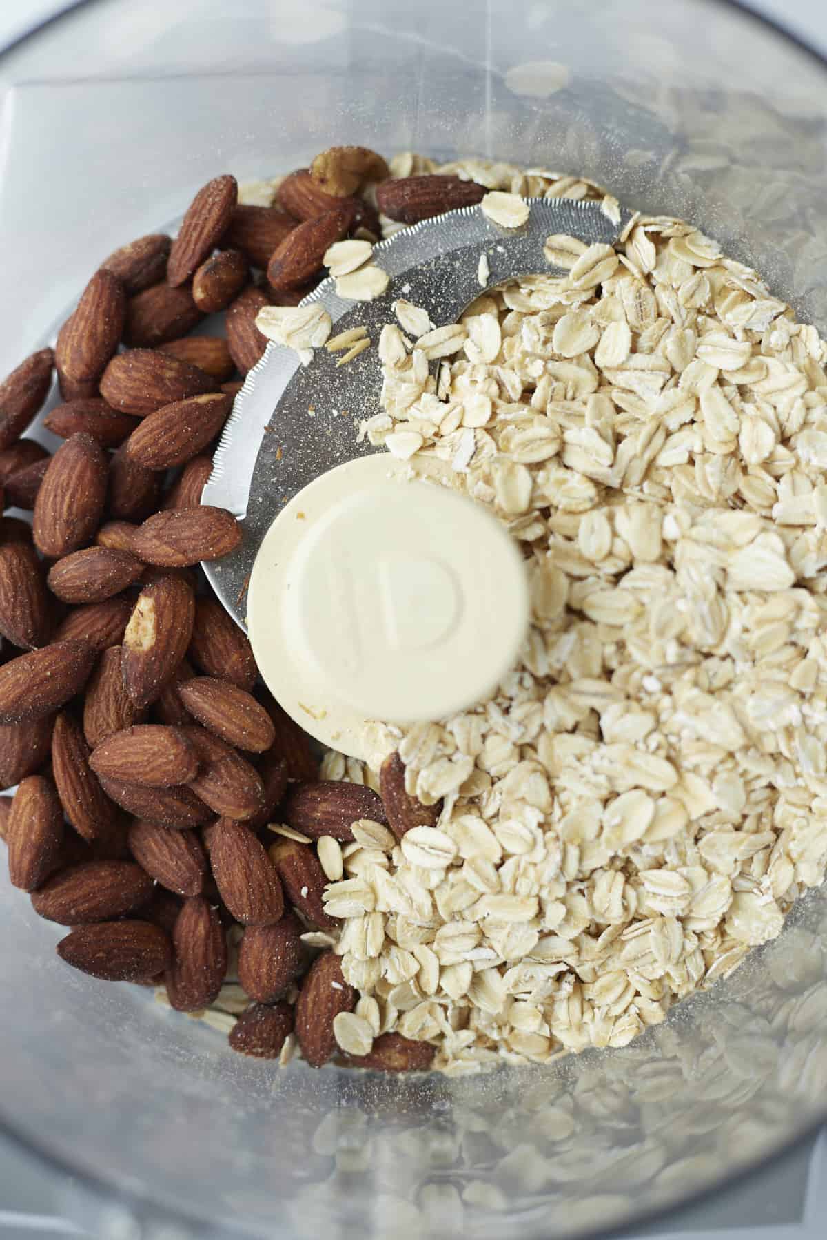 overhead image of whole oats and almonds in a food processor