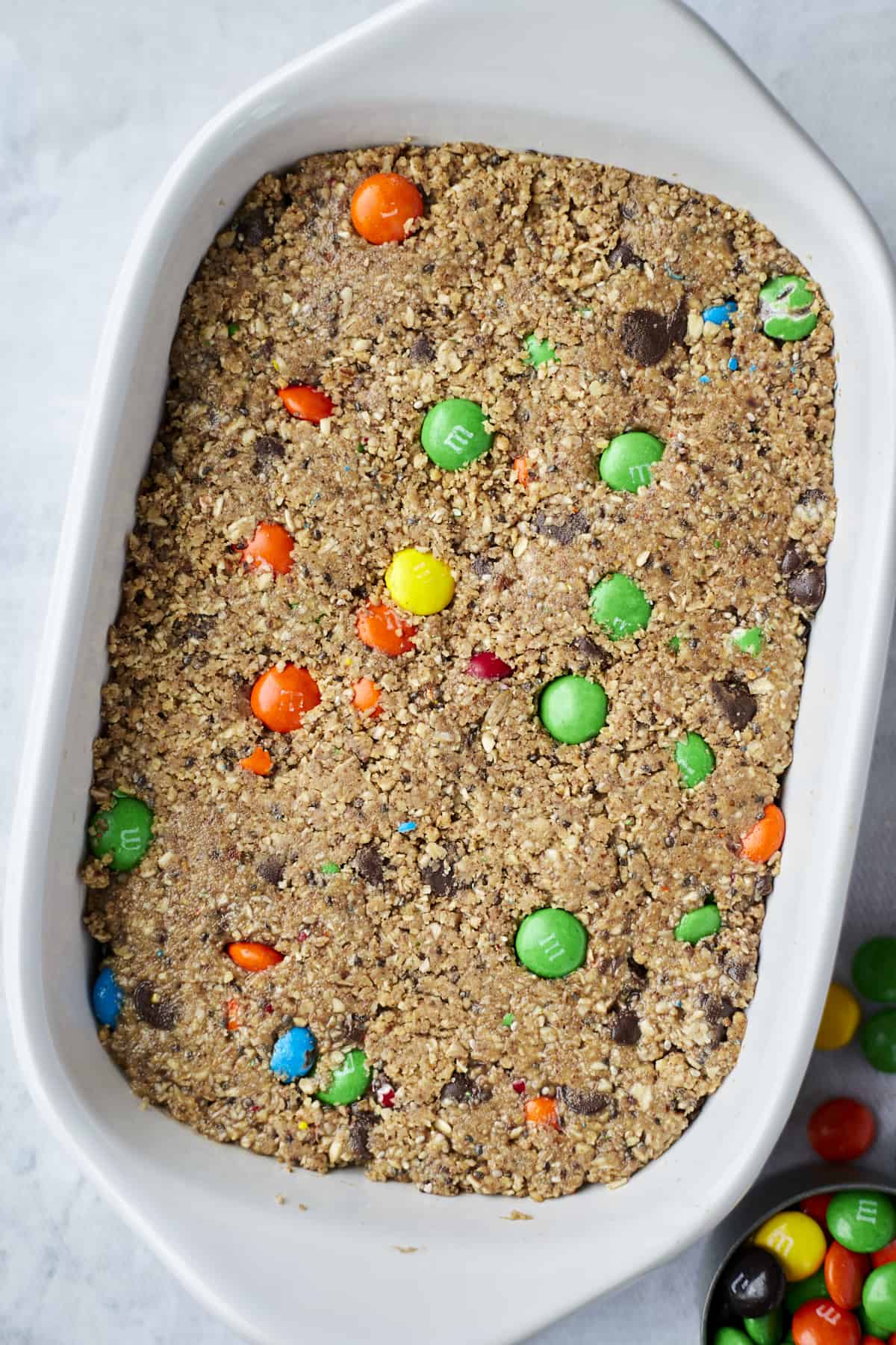 overhead of monster cookie bars with mms in a baking dish