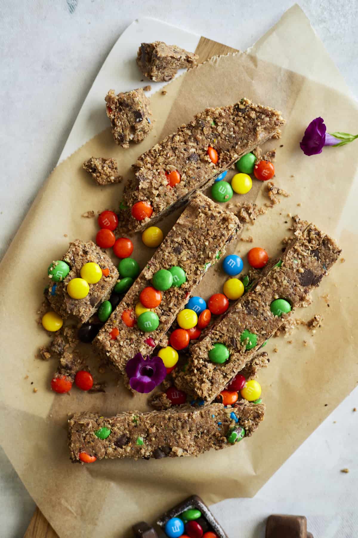 overhead of monster cookie bars with mms over brown parchment paper